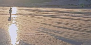女孩在冰上行走。孩子在暴风雪中冰上。雪在冰面上飞舞。雪花在贝加尔湖的冰面上飞舞。背景视图山景。