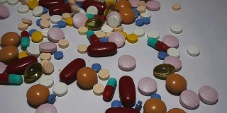五颜六色的药丸、药片和胶囊落在工作台上