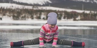 女孩在冬天练习瑜伽。孩子们在大自然的冰上做伸展运动和冥想。孩子们练习瑜伽，用碎冰做麻绳。孩子们在户外做运动健身。