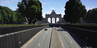 早上在布鲁塞尔五泉镇公园隧道。汽车在标志性的凯旋门纪念碑前行驶