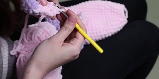 这个女孩编织了一个玩具。特写镜头