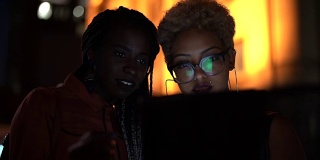 两个女人在晚上用平板电脑庆祝