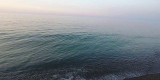 在海滩上拍摄美丽的夏日日落。海上无人机拍摄的日落画面