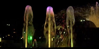 夜间喷泉中五彩缤纷的水流，动作超慢。