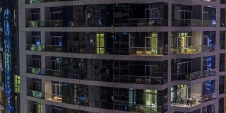 美丽的摩天大楼的窗户在晚上的时间流逝
