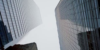 低角度滑翔拍摄的摩天大楼在纽约市。金融区。垂直POV小车风格拍摄。