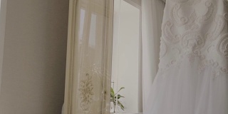 旅馆房间里衣架上的蓬松婚纱。婚礼的早晨