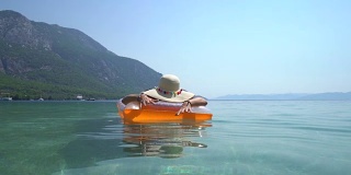 戴着帽子的中年妇女，在海边休息。Marmaris土耳其