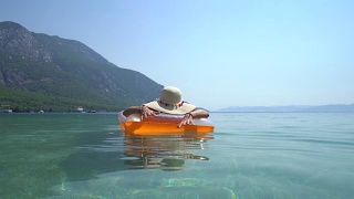 戴着帽子的中年妇女，在海边休息。Marmaris土耳其视频素材模板下载