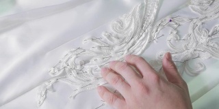 针线特写，绣花图案。用于缝制优雅婚纱的设备。手工制作的