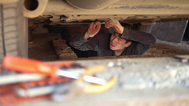 男机械师在车库里修理他的车