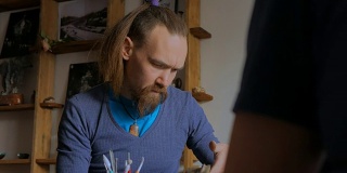 一名男子正在陶艺室演示如何制作陶土马克杯