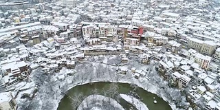 鸟瞰图的城市景观在冬天与白雪覆盖的屋顶和蜿蜒的河床