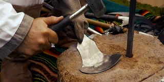 工匠用铁锤和铁砧打造手链的历史再现