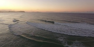 冲浪者在日落的海洋鸟瞰