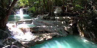 瀑布和美丽的热带自然与阳光透过树。泰国北碧府四面瀑布。4k分辨率
