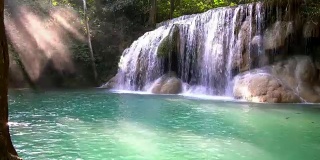 瀑布和美丽的热带自然与阳光透过树。泰国北碧府四面瀑布。4k分辨率