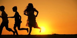 5个孩子一家人在夕阳下奔跑的剪影
