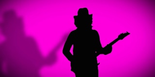戴着帽子，带着影子的酷摇滚吉他手正在粉色背景上弹奏电吉他。
