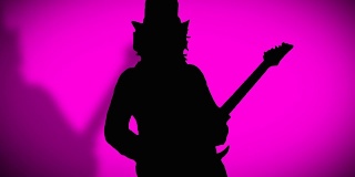 戴着帽子，带着影子的酷摇滚吉他手正在粉色背景上弹奏电吉他。