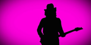 戴着帽子的酷摇滚吉他手正在粉色背景上弹奏电吉他。