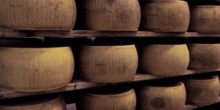 货架上满是成熟的帕尔玛干酪，生产商制造