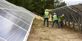 工程师在现场检查太阳能电池板，环保电力生产，可持续可再生能源