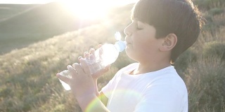 男孩正在喝塑料瓶里的水