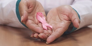 一个女性医生拿着粉红丝带为乳腺癌意识的特写