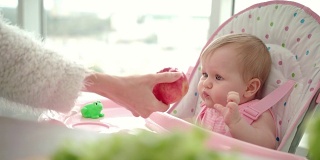 孩子吃苹果。婴儿健康食品概念。甜美的婴儿吃水果