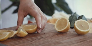 女性的手在切菜板上切新鲜的柠檬