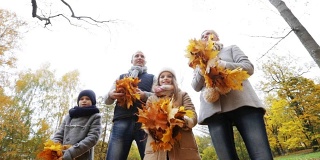 快乐的一家人在公园里玩着秋叶