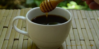 用木勺舀入蜂蜜的黑咖啡