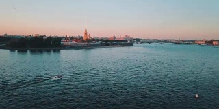 鸟瞰涅瓦河上的日落在圣彼得堡，俄罗斯。从上面的维丝利夫斯基岛城市，无人机拍摄的电影视频，北部首都的历史建筑
