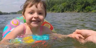 快乐的孩子在水中围成一个充气圈