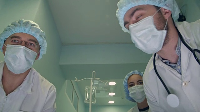 一组外科医生在去手术室的路上低头看着病人