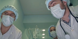 一组外科医生在去手术室的路上低头看着病人
