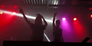 夜店里，两个年轻漂亮的女DJ在调音台播放音乐