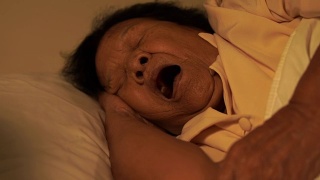 患有失眠症的老妇人正试图晚上在床上睡觉视频素材模板下载