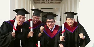 成功的毕业生穿着学位服，拿着学位证书，看着相机，微笑着跳到户外拍照。