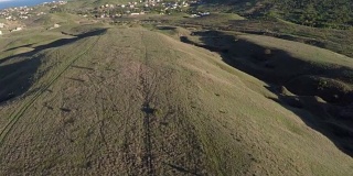 无人机空中飞行日落山谷与丘陵在阳光明媚的一天