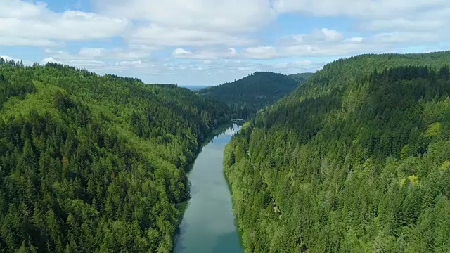 空中飞行在细河之间的山区森林云倒映在蓝色的水