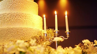 优雅的婚礼蛋糕装饰与蜡烛。视频素材模板下载