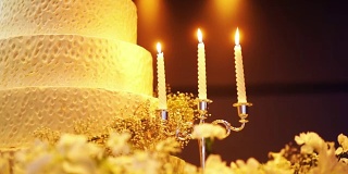 优雅的婚礼蛋糕装饰与蜡烛。