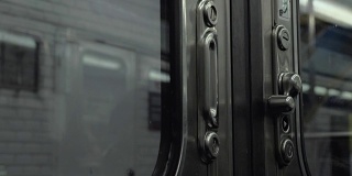 离开地铁列车，透过紧闭的门从里面看到