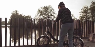骑自行车的老妇人在湖边享受她的时光