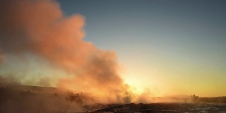 冰岛间歇泉喷发。冬天的冷色，阳光透过蒸汽照射