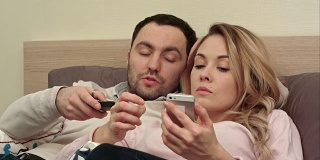 年轻夫妇晚上在床上吵架就因为女人用智能手机给别人发短信