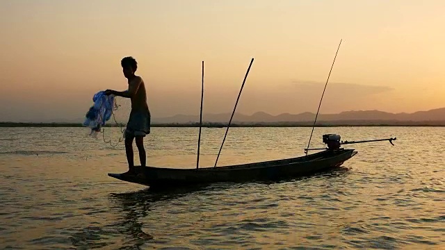 泰国渔民在长尾船上捕鱼