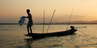 泰国渔民在长尾船上捕鱼